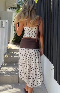 Rear view of polka dot crop top and matching maxi skirt set with wide brown waistband