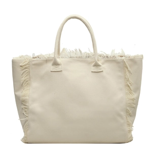 Minimalist beige canvas tote bag with fringe details and top handles on white background
