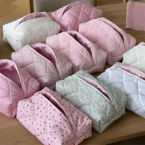 Flat lay of quilted cotton cosmetic bags in floral and striped patterns on wood