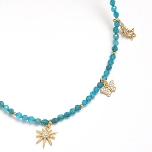 Detail of blue beaded necklace with gold sun butterfly star pendants and zircons