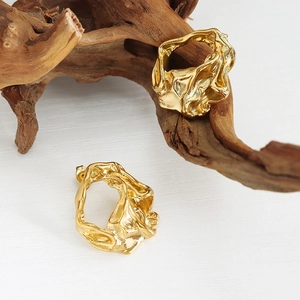 Lava-style textured gold stainless steel earrings displayed on natural wood