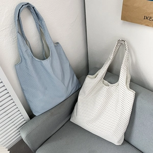 Detailed shot of retro polka dot canvas tote bags in light blue and cream colors