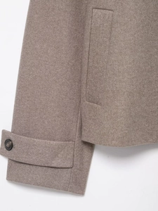 Detail of wool coat cuff with button strap and high-quality stitching on oatmeal fabric
