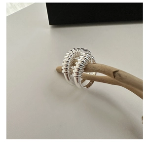 Detalle macro del anillo curvo de plata esterlina S925 sobre una rama de madera