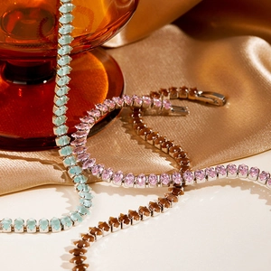 Detailed close-up of multi-color zircon tennis bracelets on a luxury silk background