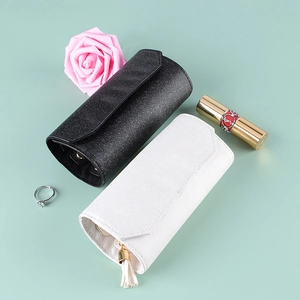 Portable lychee leather jewelry roll organizer in black and white with tassel detail