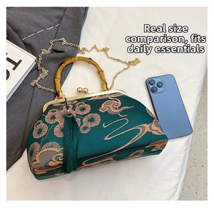 Detaillierte Ansicht der grünen Sticktasche mit Bambusgriff und Handy zum Größenvergleich