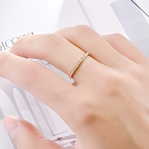 Gros plan détaillé d'une bague minimaliste en acier titane de 2 mm avec pavé de pierres sur une main