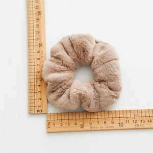 Macro shot of a soft light brown faux fur scrunchie showing a 10cm diameter measurement