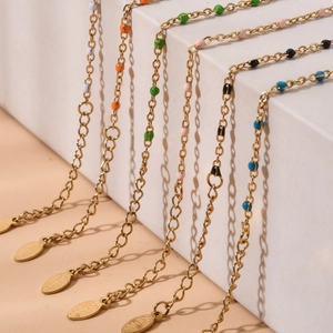 Detail of stainless steel gold chain with colorful enamel beads and extender tag