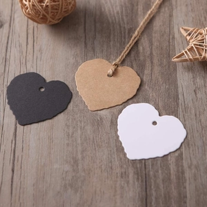 Three heart-shaped kraft gift tags in black, brown, and white with scalloped edges and twine