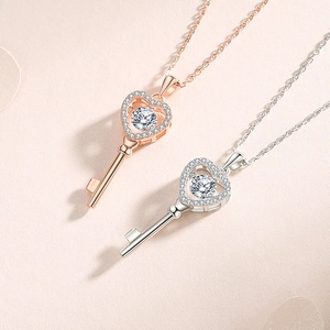Moissanite heart key necklaces in silver and rose gold finishes on pink background
