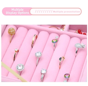 Detail view of various gold and silver rings set in pink velvet jewelry box tray