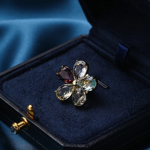 Elegant floral crystal brooch with colorful pear-cut gemstones in a blue velvet box