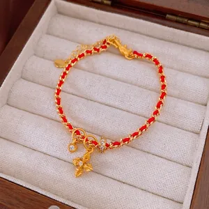 Gold plated heart and cross charm bracelet with red woven cord and zircon accents