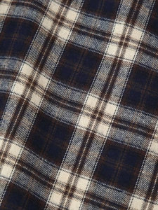 Detailed macro shot of the blue and brown plaid flannel fabric with fine brushed texture