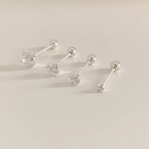 Macro shot of 925 silver stud earrings with four sizes of round cubic zirconia stones