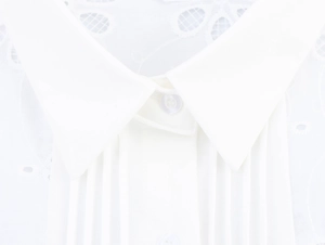 Detail of white blouse with lace embroidery, pintuck pleats and classic pointed collar