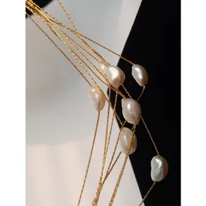 Elegant multi-layer gold chain necklace with natural baroque pearls in minimalist style