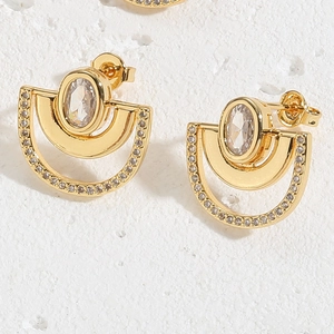 Macro shot of 14K gold plated U-shaped stud earrings with oval zircon and pavé crystals
