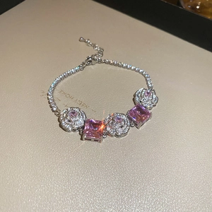 Macro view of flower bracelet with pink rectangular stones and pave diamond roses