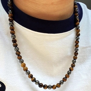 Detail showing polished tiger eye and hematite beads on a men's hip hop necklace