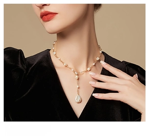 Baroque freshwater pearl Y-necklace on a model wearing a black velvet V-neck top