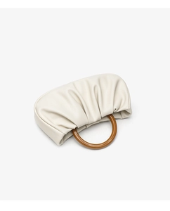 Detail view of the soft pleated ivory cloud bag featuring a round resin top handle