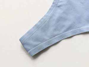 Dettaglio ravvicinato delle cuciture del perizoma sportivo azzurro e tessuto elastico