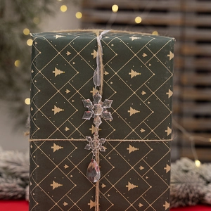 Macro shot of clear acrylic snowflake and icicle ornaments on green gift box