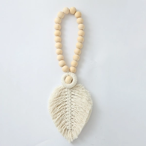 Detail of handcrafted bohemian cotton leaf pendant with natural wooden beads decoration