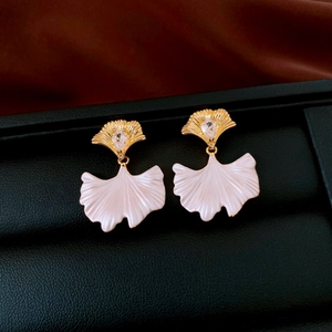 Macro shot of ginkgo leaf earrings with drop zircon and pearlescent pink texture