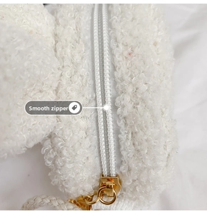 Detail of soft white plush fabric and high-quality gold zipper with smooth gliding action
