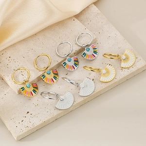 Detail of fan-shaped titanium earrings with colorful enamel and bead on stone pedestal