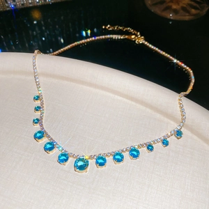 Sparkling gold necklace with round blue gemstones and micro-paved zircon crystals
