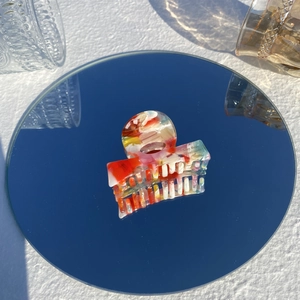 Colorful acetate marble texture hair claw clip shown with elegant reflection on mirror