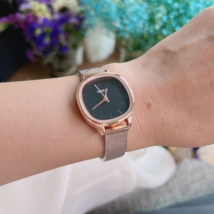 Elegant women's square quartz watch with golden mesh strap and black dial on model's wrist