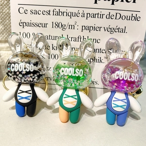 Close-up of three acrylic rabbit keychains with flowing glitter and liquid details
