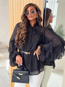 Detail of elegant black chiffon blouse with tiered ruffle cuffs and delicate neck tie bow
