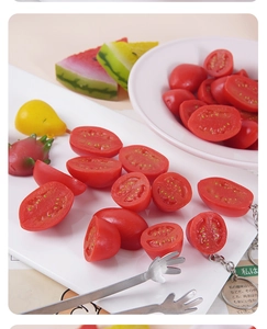 Detailed macro view of lifelike miniature tomato and assorted fruit keychain charms