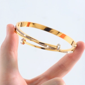 Close-up of a double-layer nail-shaped gold bangle featuring sparkling CZ stones on a hand
