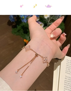 Detail of rose gold clover bracelet with zircon pavé and adjustable pull chain