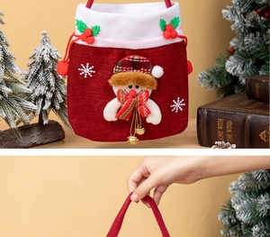 Detail of red Christmas gift bag featuring a soft white plush trim and cute cartoon doll
