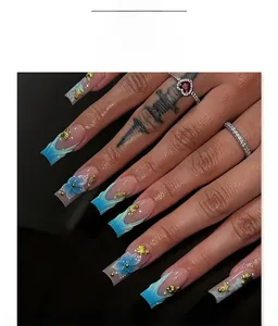 Detailed view of blue gradient press-on nails with 3D floral accents and pearl gems