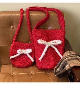 Detailed view of red plush bucket bags with white bows on a vintage leather sofa