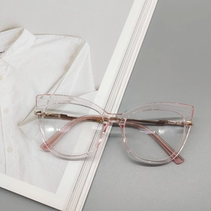 Dettaglio di occhiali cat-eye rosa trasparente con aste in metallo dorato su sfondo neutro