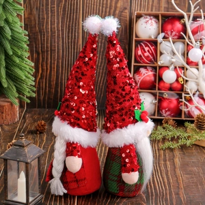Poupées gnomes de Noël avec chapeaux à paillettes rouges sur fond de bois rustique