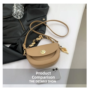 Detail of khaki saddle bag showing gold clasp lock and silk scarf wrapped chain handle
