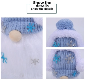 Close-up of a blue knitted gnome with silver sequin snowflakes and white plush faux fur