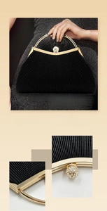 Detail of black pleated evening clutch with crystal clasp and golden semicircular handle